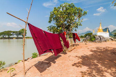 Small stupa and laundry at Kyaut Ka Lat (Kyaut Kalat or Kyauk Kalap) temple near Hpa An, Myanmarの写真素材