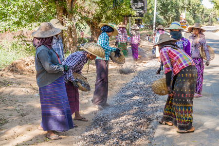 BAGAN, MYANMAR - DECEMBER 6, 2016: Local road workers building a macadam road in Bagan, Myanmarのeditorial素材