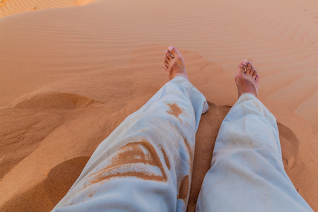 Legs of a man in the sand dunes of Sharqiya (Wahiba) Sands, Omanの写真素材