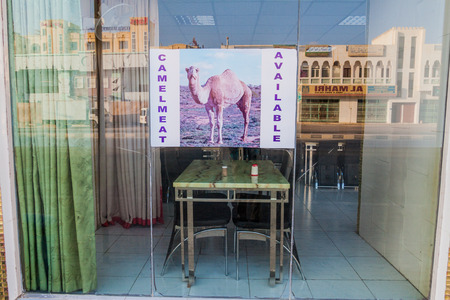 SALALAH, OMAN - FEBRUARY 24, 2017: View of a local restaurant with a poster: Camel meat available in Salalah.のeditorial素材