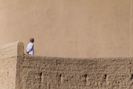 BAHLA, OMAN - FEBRUARY 27, 2017: Local man at a wall of Bahla Fort, Omanのeditorial素材