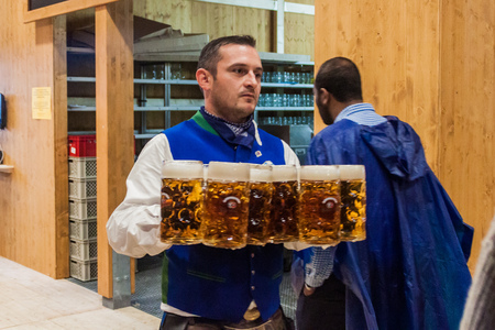 MUNICH, GERMANY - SEPTEMBER 17, 2016: Waiter carrying many beer glasses at the Oktoberfest in Munichのeditorial素材