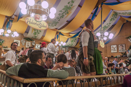 MUNICH, GERMANY - SEPTEMBER 17, 2016: People drink beer in one of the tents of the Oktoberfest in...