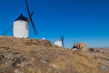 Windmills and a castle in Consuegra village, Spainの写真素材