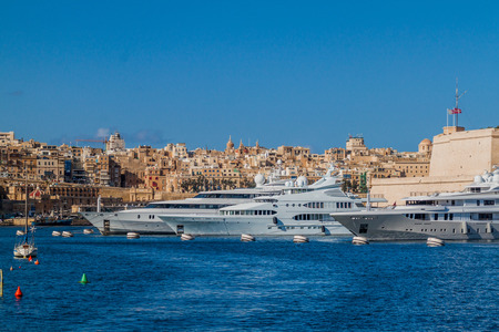Yachts berthed at the port in Birgu town, Malta. Valletta in the background.のeditorial素材