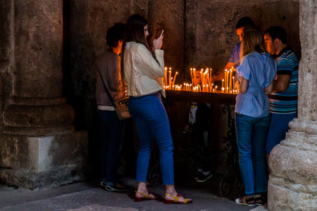 HAGHARTSIN, ARMENIA - JULY 11, 2017: Devotees burning candles in Haghartsin monastery in Armenia