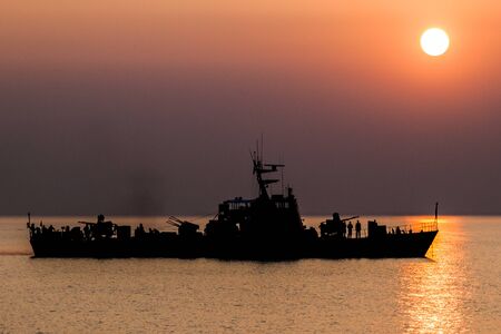 Sunset at the mouth of Pasur river with a silhouette of a Coast Guard ship, Bangladesh
