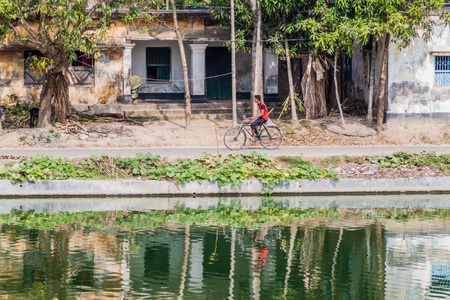 PUTHIA, BANGLADESH - NOVEMBER 10, 2016: Cyclist on the banks of Gopal Chowki pond in Puthia village, Bangladeshのeditorial素材