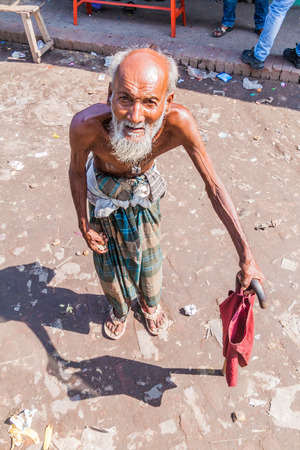 BAGERHAT, BANGLADESH - NOVEMBER 18, 2016: Old man with a stick on a bus stand in Bagerhat, Bangladeshのeditorial素材