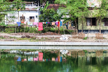 PUTHIA, BANGLADESH - NOVEMBER 10, 2016: Laundry on the banks of Gopal Chowki pond in Puthia village, Bangladeshのeditorial素材