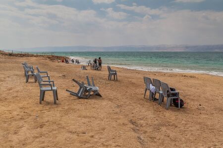 AMMAN BEACH, JORDAN - MARCH 21, 2017: People and plastics chairs at Amman Beach at the Dead Sea,...