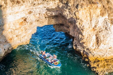 LAGOS, PORTUGAL - OCTOBER 7, 2017: Tourist boat at the cliffs near Lagos, Portugal.の写真素材