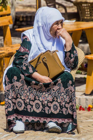KHIVA, UZBEKISTAN - APRIL 25, 2018: Local old woman in the old town of Khiva, Uzbekistanのeditorial素材
