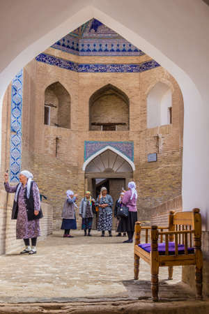 KHIVA, UZBEKISTAN - APRIL 25, 2018: Local tourists visiting Allakuli Khan Madrassah in the old town of Khiva, Uzbekistanのeditorial素材