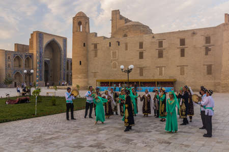 BUKHARA, UZBEKISTAN - APRIL 30, 2018: Dancers and musicians wearing traditional dress in the center...