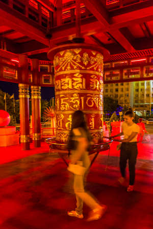 ELISTA, RUSSIA - JUNE 27,2018: Young Buddhist girls at a praying wheel in the Pagoda of Seven Days in Elista, Russia.のeditorial素材