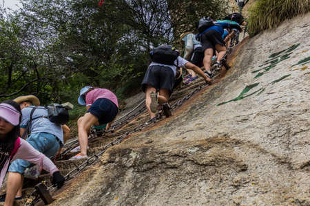 HUA SHAN, CHINA - AUGUST 4, 2018: People climb at the stairs leading to the peaks of Hua Shan mountain in Shaanxi province, Chinaのeditorial素材