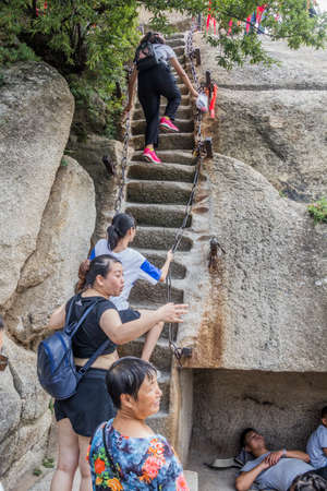 HUA SHAN, CHINA - AUGUST 4, 2018: People climb at the stairs leading to the peaks of Hua Shan mountain in Shaanxi province, Chinaのeditorial素材