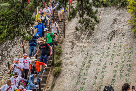 HUA SHAN, CHINA - AUGUST 4, 2018: People climb at the stairs leading to the peaks of Hua Shan mountain in Shaanxi province, Chinaのeditorial素材