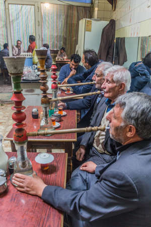 ARDABIL, IRAN - APRIL 10, 2018: Water pipe smokers in a traditional tea house in Ardabil.