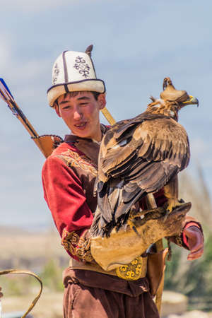 ISSYK KUL, KYRGYZSTAN - JULY 15, 2018: Local man with his eagle at the Ethnofestival Teskey Jeek at the coast of Issyk Kul lake in Kyrgyzstanのeditorial素材