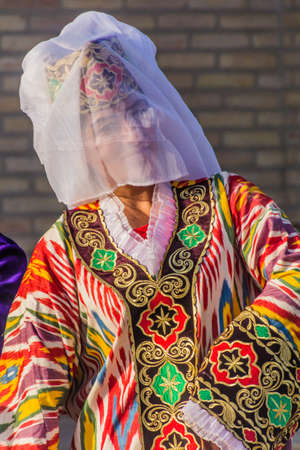 BUKHARA, UZBEKISTAN - APRIL 30, 2018: Young dancer in a traditional dress in the center of Bukhara, Uzbekistanのeditorial素材