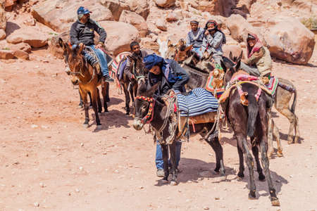 PETRA, JORDAN - MARCH 24, 2017: Local man with donkeys in the ancient city Petra, Jordan