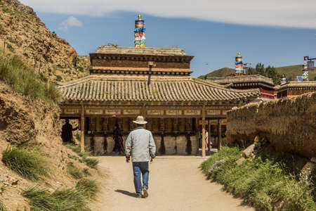 People walk at the Inner Kora (pilgrim path) around Labrang Monastery in Xiahe town, Gansu province,...