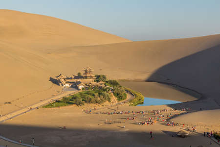 DUNHUANG, CHINA - AUGUST 21, 2018: Crescent Moon Lake at Singing Sands Dune near Dunhuang, Gansu Province, Chinaのeditorial素材
