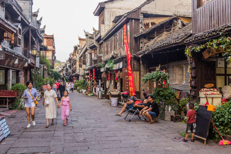 FENGHUANG, CHINA - AUGUST 13, 2018: Crowded cobbled street in Fenghuang Ancient Town, Hunan province, Chinaのeditorial素材