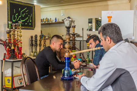 ARDABIL, IRAN - APRIL 11, 2018: Local people with waterpipes in a tea house in Ardabil, Iran