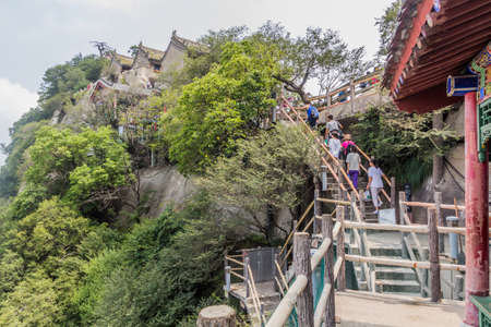 HUA SHAN, CHINA - AUGUST 4, 2018: People climb at the stairs leading to the peaks of Hua Shan mountain in Shaanxi province, Chinaのeditorial素材