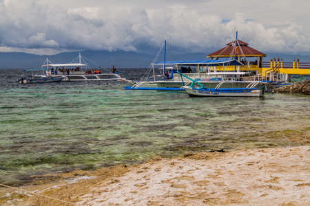 MOALBOAL, PHILIPPINES - FEBRUARY 13, 2018: Various boats off coast in Moalboal, Cebu island,...