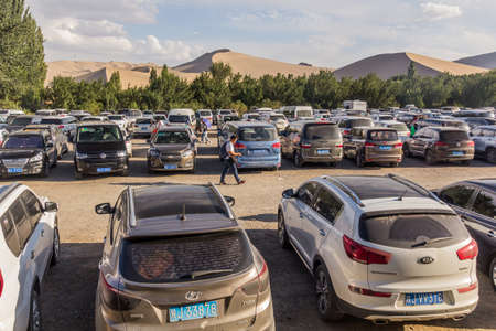 DUNHUANG, CHINA - AUGUST 20, 2018: Parking lot at  Singing Sands Dune near Dunhuang, Gansu Province, Chinaのeditorial素材