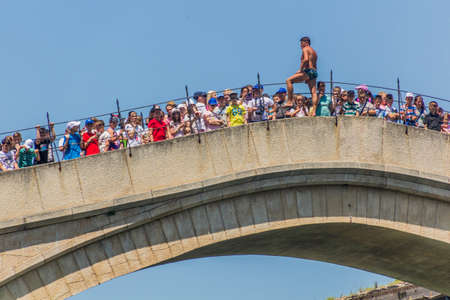 MOSTAR, BOSNIA AND HERZEGOVINA - JUNE 10, 2019: Man is preparing to jump from Stari most (Old Bridge) in Mostar. Bosnia and Herzegovinaのeditorial素材