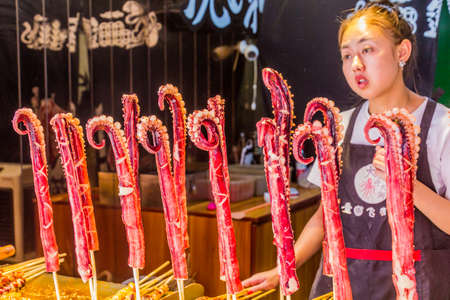 CHONGQING, CHINA - AUGUST 17, 2018: Squid skewers stall in Ciqikou Ancient Town, Chinaのeditorial素材