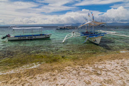 MOALBOAL, PHILIPPINES - FEBRUARY 13, 2018: Various boats off coast in Moalboal, Cebu island, Philippinesのeditorial素材