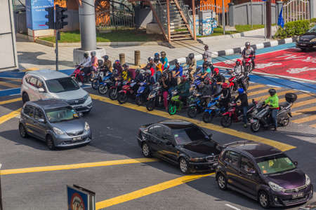 KUALA LUMPUR, MALAYSIA - MARCH 30, 2018: Motorbikes wait at a road intersection in Kuala Lumpur,...