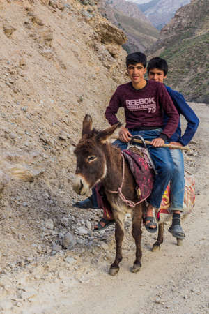 HAFT KUL, TAJIKISTAN - MAY 10, 2018: Boys riding a donkey in Marguzor (Haft Kul) in Fann mountains, Tajikistanのeditorial素材