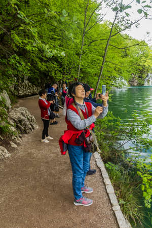 PLITVICE, CROATIA - MAY 24, 2019: Tourists take photos in Plitvice Lakes National Park, Croatiaのeditorial素材