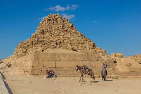 CAIRO, EGYPT - JANUARY 28, 2019: People with horses near Queens' pyramids in Giza, Egypt