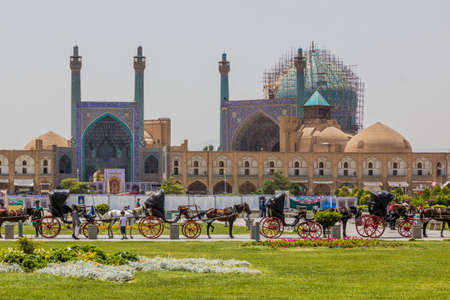 ISFAHAN, IRAN - JULY 10, 2019: Horse carriages in front of Shah Mosque at Naqsh-e Jahan Square in Isfahan, Iranのeditorial素材