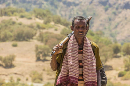 SIMIEN MOUNTAINS, ETHIOPIA - MARCH 15, 2019: Armed scout guarding tourists in Simien mountains, Ethiopiaのeditorial素材