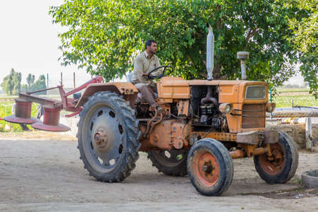 BAHAR, IRAN - JULY 13, 2019: Local farmer on his tractor near Bahar, Iran.