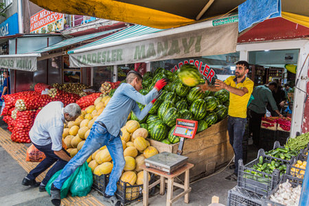 KARS, TURKEY - JULY 18, 2019: Workers throwing and catching melons in a fruit and vegetable shop in Kars, Turkeyのeditorial素材