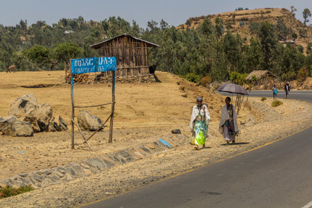 KOSOYE, ETHIOPIA - MARCH 14, 2019: People walking on a road in Kosoye village, Ethiopia