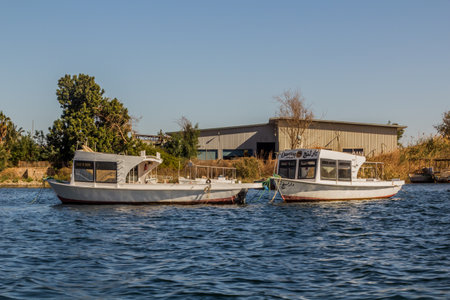ASWAN, EGYPT - FEB 13, 2019: Boats at the Aswan High Dam reservoir from the dam, Egypt