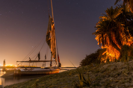 Night view of a felucca sail boat at the river Nile, Egyptの写真素材