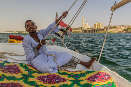 ASWAN, EGYPT: FEB 15, 2019: Crewman of a felucca sail boat at the river Nile near Aswan, Egypt