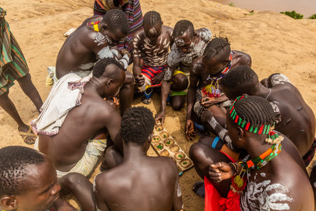 KORCHO, ETHIOPIA - FEBRUARY 4, 2020: Men of Karo tribe playing mancala (bao) game in Korcho village,...